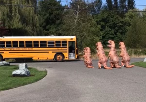 Mire a esta familia T-Rex esperar el autobús escolar